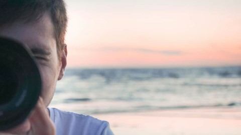 Michel Grolet taking a picture on the beach at sunset